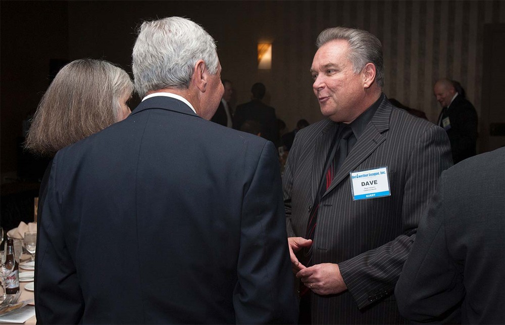 Cadence Health’s Dave Valestin (right) converses with Bellwether Class of 2014 Honoree Joe Pleasant (center, back to camera) and wife Vicki Pleasant (left).