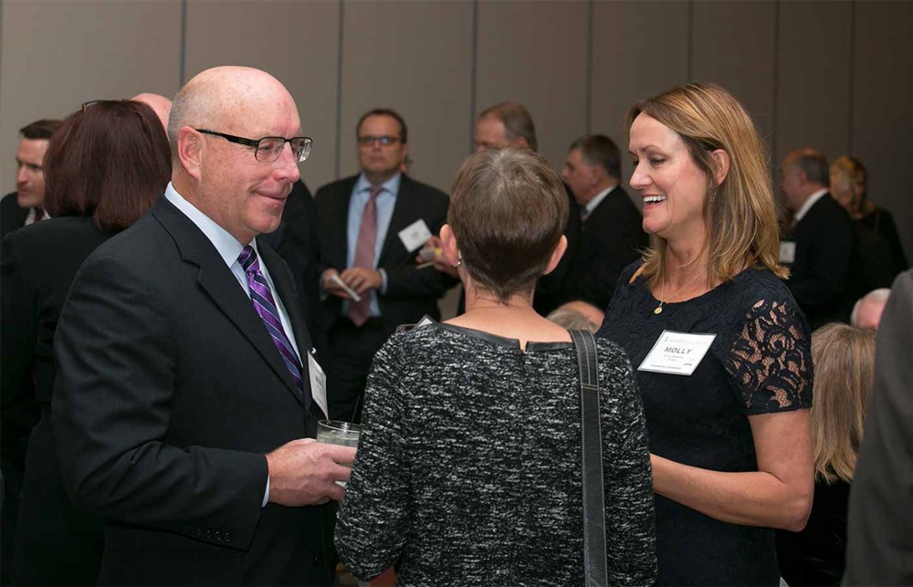Vizient’s Mike McMahon (left) and Molly Matthews (right) converse with Nancy LeMaster (Bellwether Class of 2015) (back to camera).